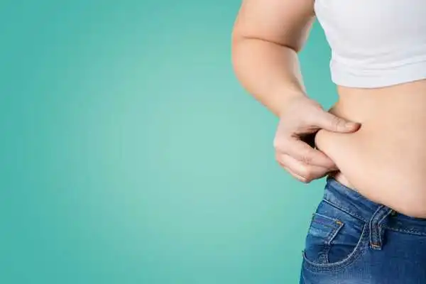 Image of woman pinching her love handles to show weight gain Thrapston